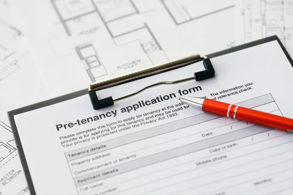 Close-up on clipboard with pre-tenancy application and red pen.